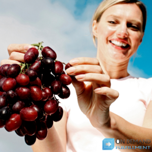 woman holding a bunch of grapes